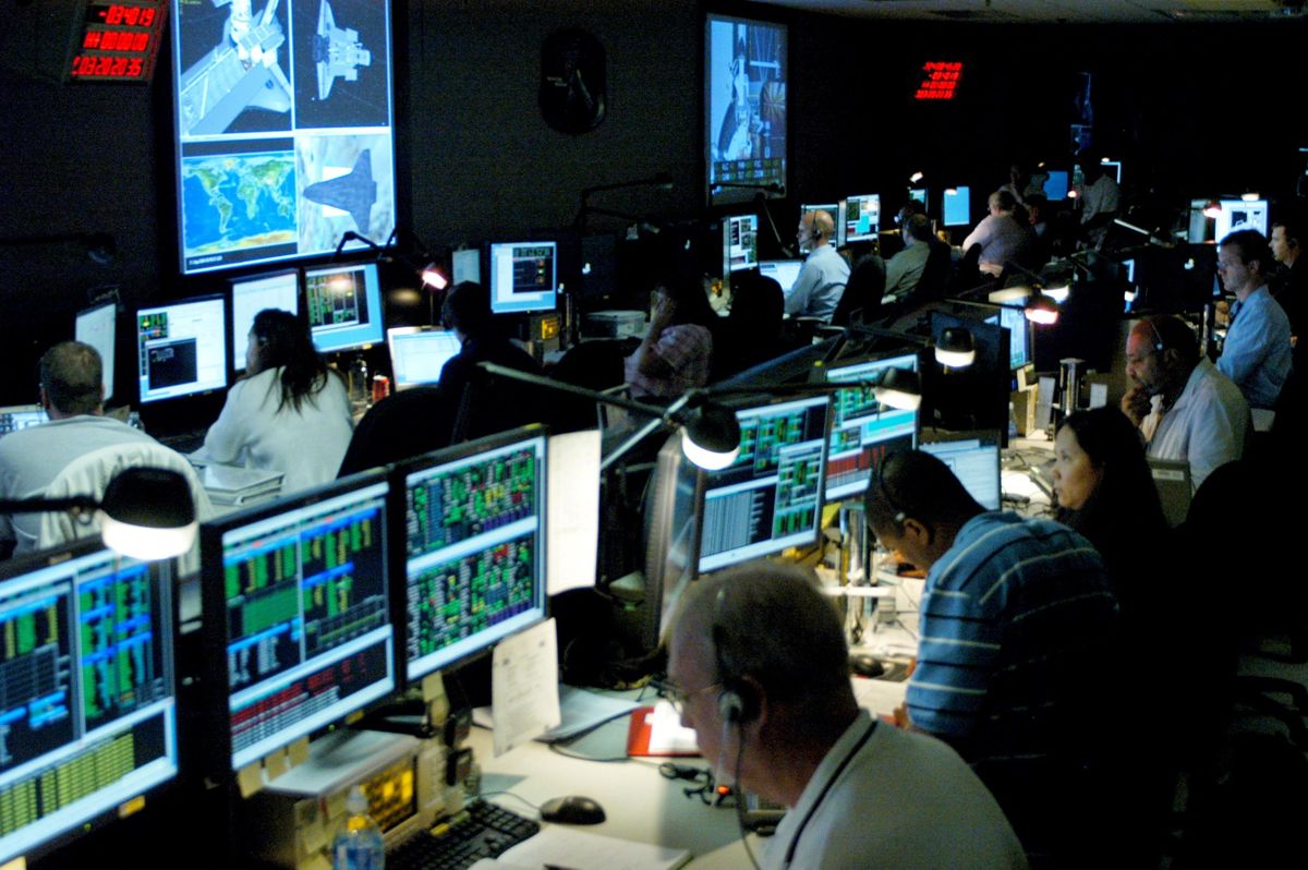 Engineers and operators working at consoles in the Hubble mission operations room