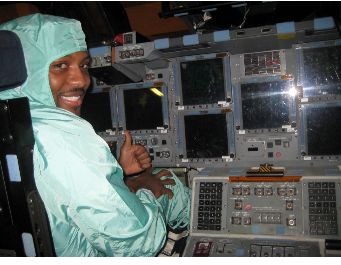 Ben Teasdel III seated inside a NASA Space Shuttle cockpit